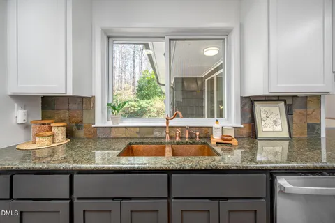 a kitchen with granite countertop a sink and a window