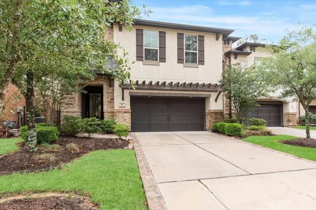 a front view of a house with a garden and garage