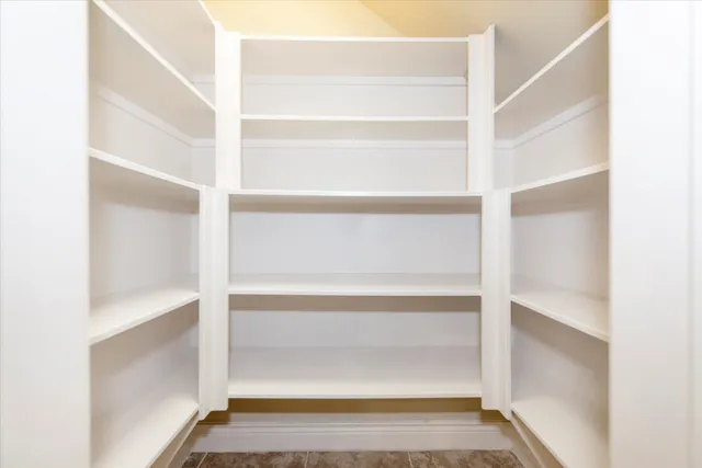 a view of walk in closet with empty racks