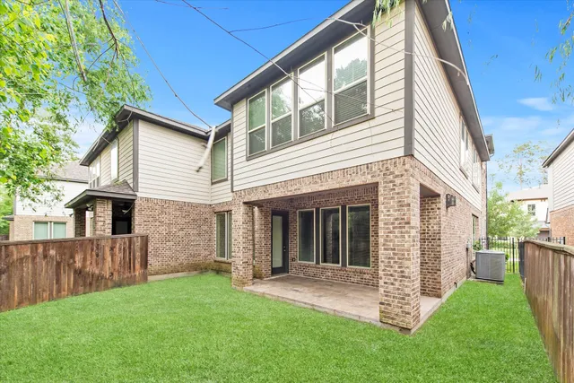 a view of a house with a yard and wooden fence