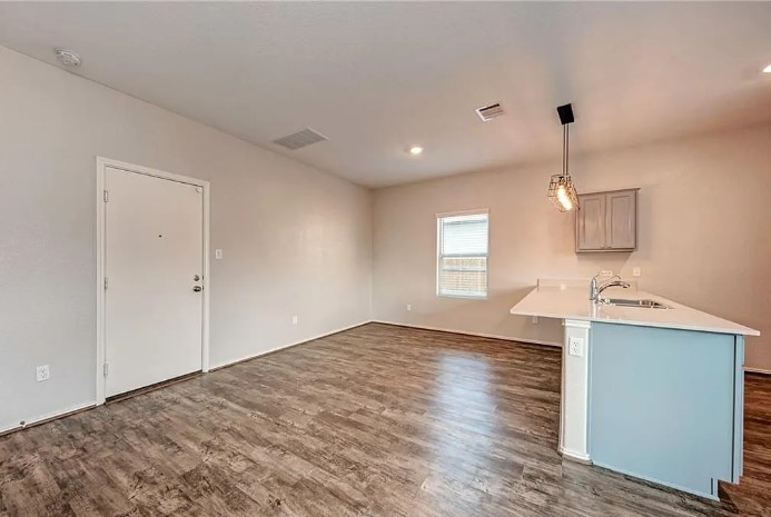 817 Circle Way, Unit 7I Jarrell, TX 76537 - Photo 15 of 33 Kitchen with pendant lighting, dark wood-style flooring, light stone counters, recessed lighting, and a kitchen breakfast bar