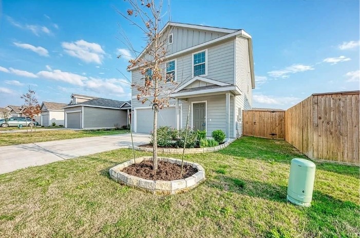 817 Circle Way, Unit 7I Jarrell, TX 76537 - Photo 2 of 33 View of front facade with board and batten siding, concrete driveway, and an attached garage