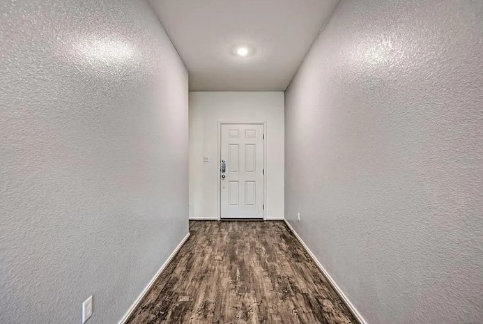 817 Circle Way, Unit 7I Jarrell, TX 76537 - Photo 4 of 33 Hallway with a textured wall and dark wood-type flooring