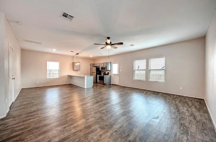817 Circle Way, Unit 7I Jarrell, TX 76537 - Photo 7 of 33 Unfurnished living room featuring dark wood-type flooring and ceiling fan