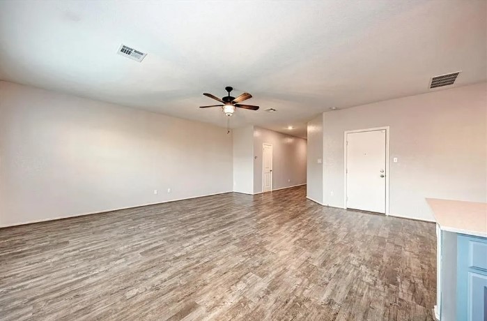817 Circle Way, Unit 7I Jarrell, TX 76537 - Photo 9 of 33 Unfurnished living room with dark wood-style flooring and a ceiling fan