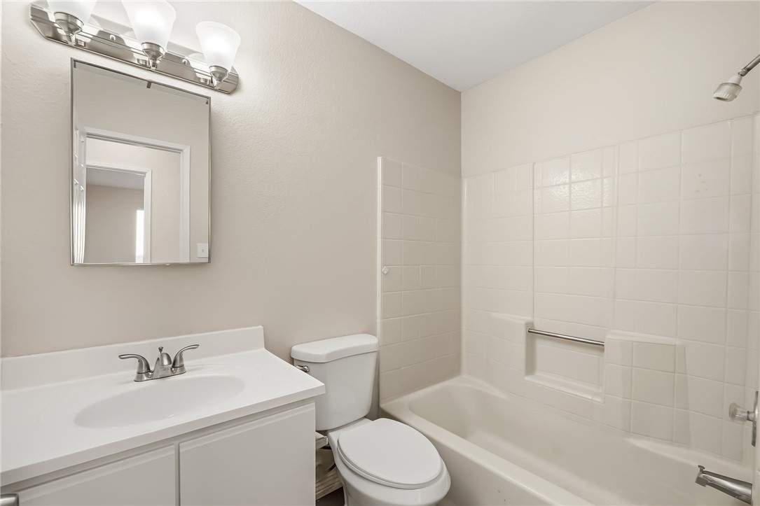 1720 Valencia Road Fort Mohave, AZ 86426 - Photo 23 of 32 Bathroom featuring a white vanity with integrated sink, brushed nickel faucet, wall-mounted mirror, and a three-light vanity fixture