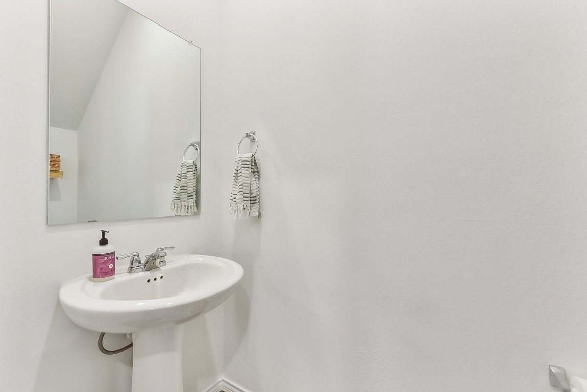 5908 Eden Drive Austin, TX 78747 - Photo 12 of 31 a bathroom with a sink a mirror and a toilet