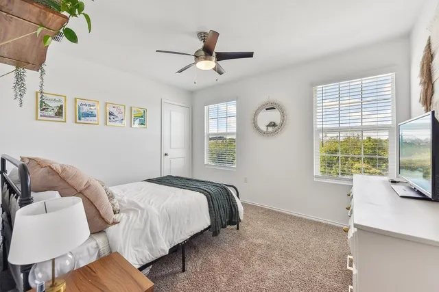 a bedroom with a bed and a flat tv screen on dresser