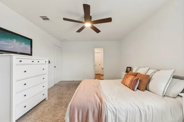 a bedroom with a bed and a flat tv screen on dresser