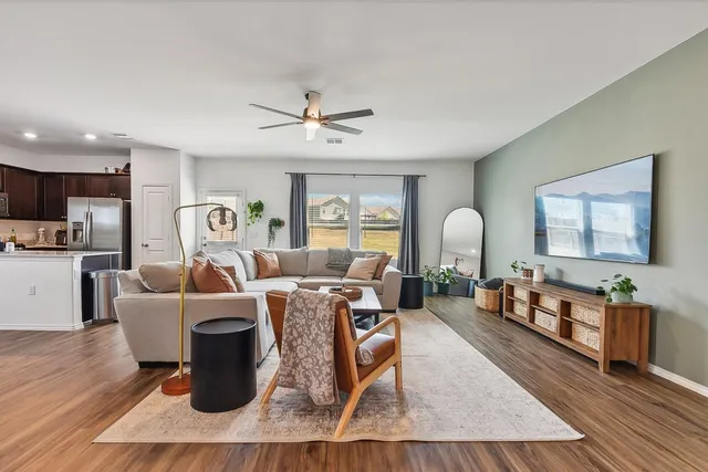 a living room with furniture a table and wooden floor