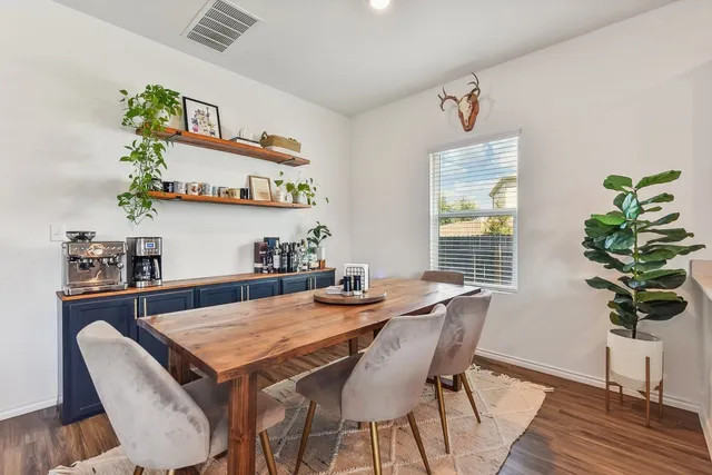 a dining room with furniture potted plants and wooden floor