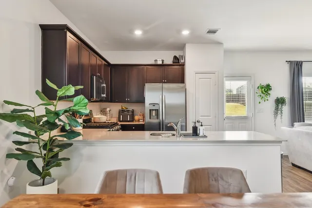 a view of kitchen with kitchen island a potted plant and a window