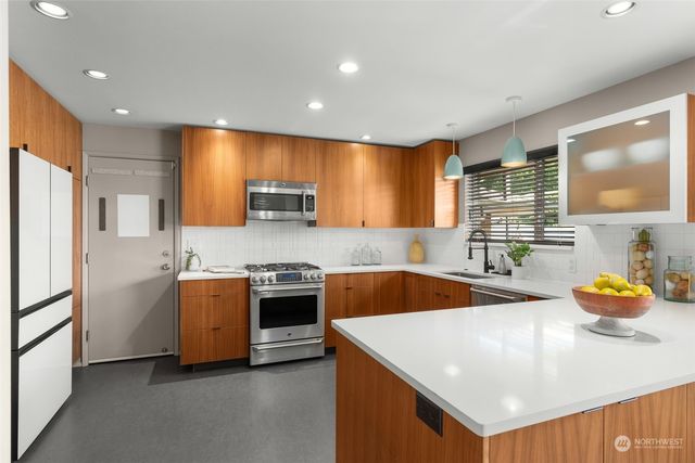 a kitchen that has a sink and a stove in it