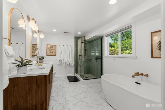 a spacious bathroom with a bathtub sink and mirror