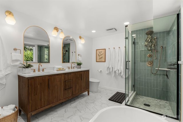 a bathroom with a double vanity sink mirror and shower