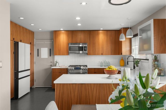 a kitchen that has a lot of cabinets a sink and a refrigerator