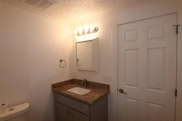 a bathroom with a granite countertop sink and vanity