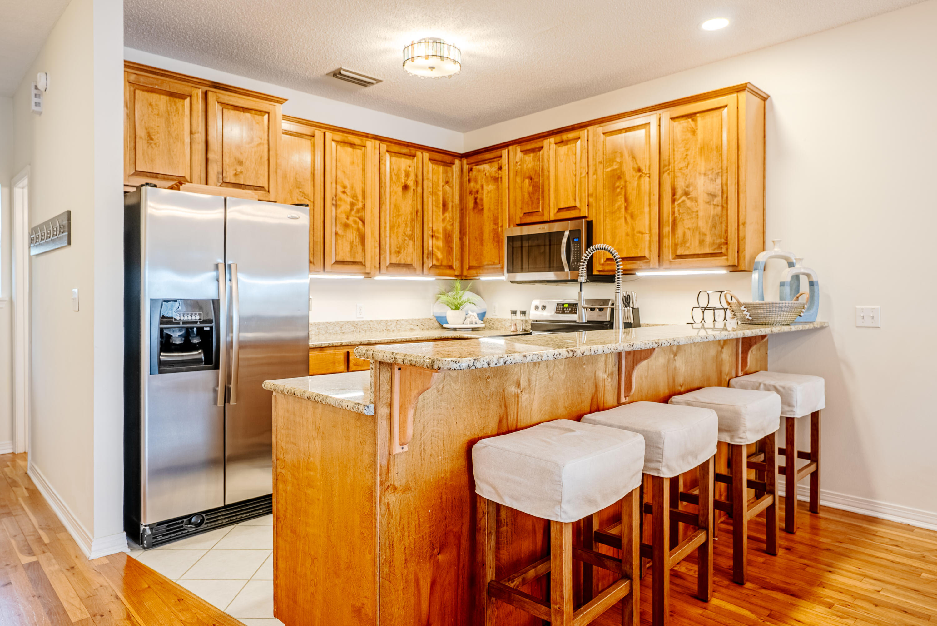 10 Mar-A-Lago Boulevard, Unit 14 Santa Rosa Beach, FL 32459 - Photo 10 of 47 a kitchen with stainless steel appliances granite countertop a stove a refrigerator a table and chairs