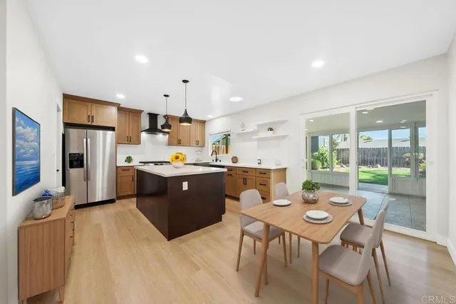 a open kitchen with stainless steel appliances kitchen island granite countertop a sink dishwasher a stove a refrigerator with island and chairs