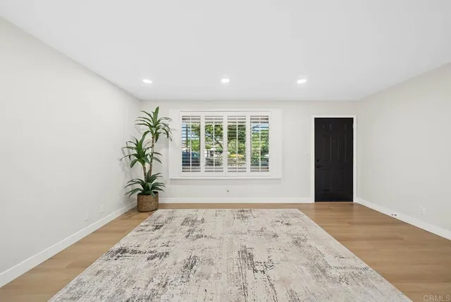 an empty room with windows and plant