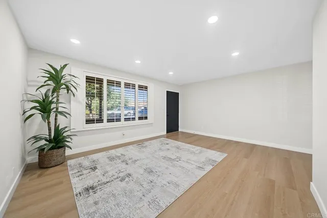 an empty room with potted plants and wooden floor