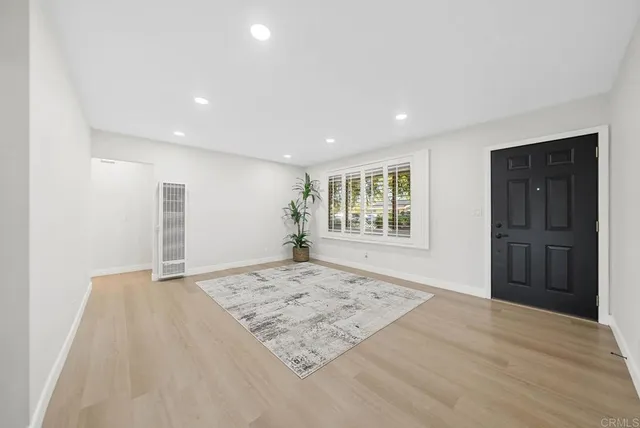 a view of empty room with wooden floor and window