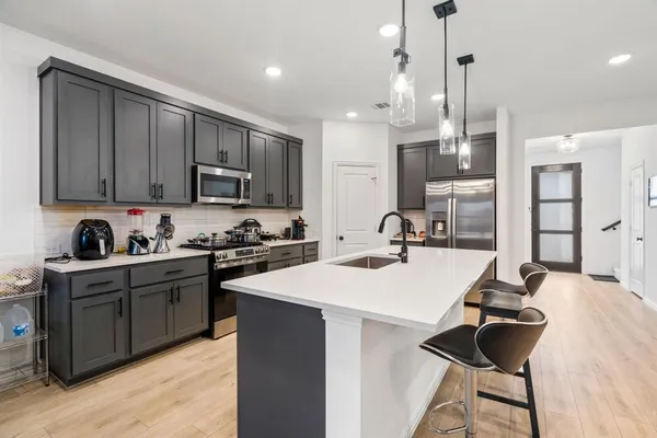 a kitchen with granite countertop a sink stainless steel appliances and cabinets