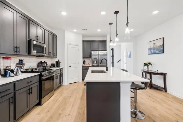a kitchen with stainless steel appliances kitchen island granite countertop a sink counter space and cabinets