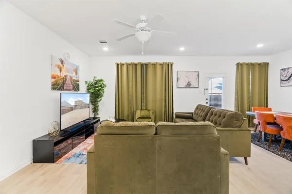 a living room with furniture a flat screen tv and a window