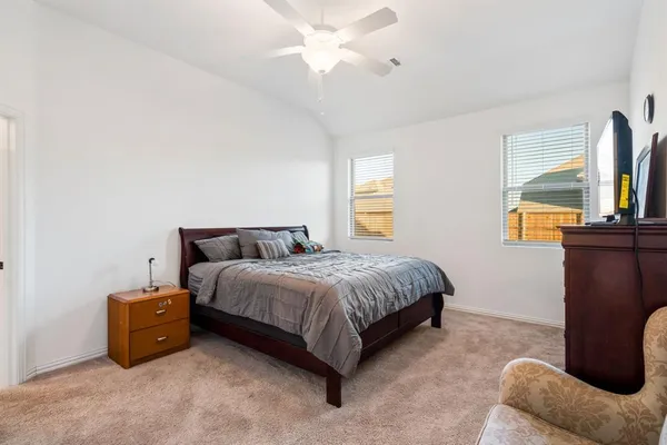 a spacious bedroom with a bed and a chandelier
