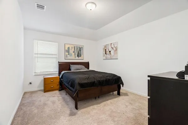 a bedroom with a bed lamp and a window