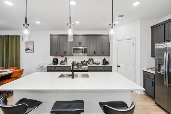 a kitchen with kitchen island a sink appliances and cabinets