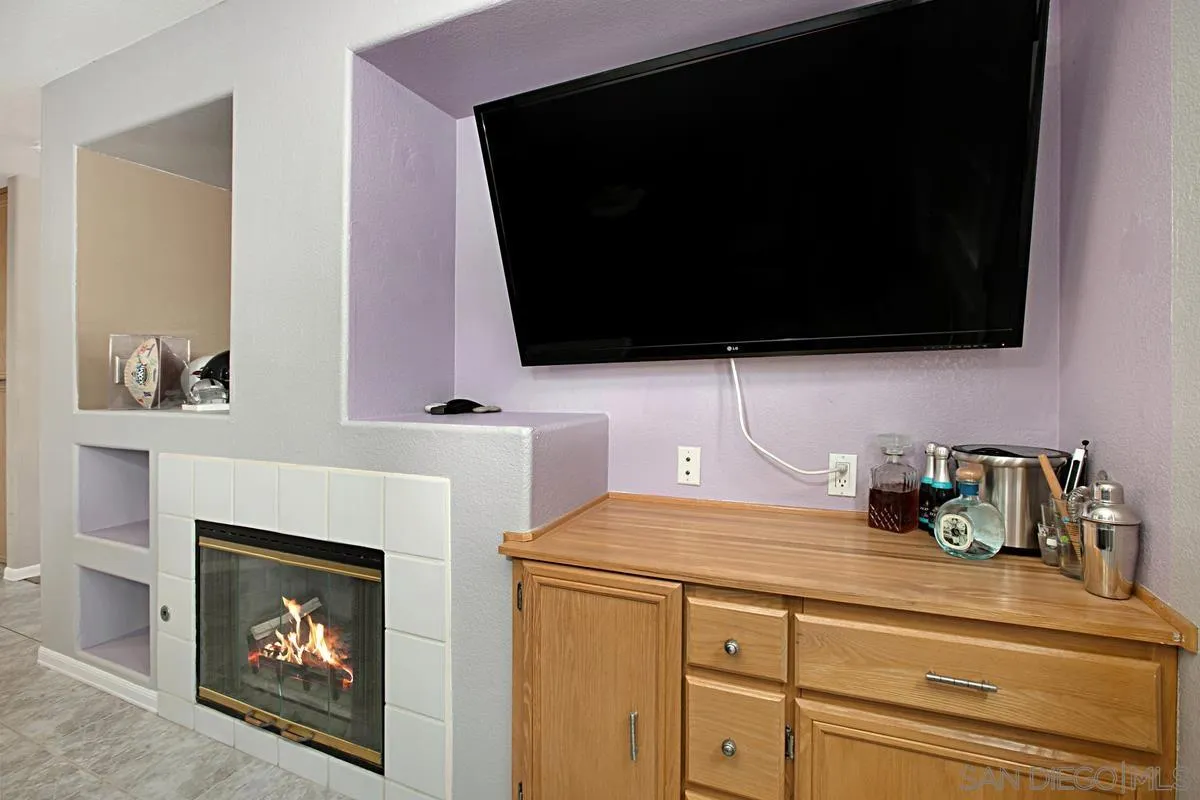 405 Whispering Willow Drive, Unit B Santee, CA 92071 - Photo 11 of 29 a kitchen with a fireplace and a flat screen tv