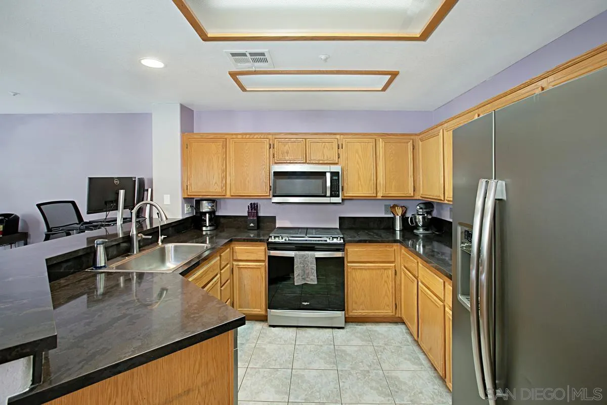 405 Whispering Willow Drive, Unit B Santee, CA 92071 - Photo 6 of 29 a kitchen with stainless steel appliances granite countertop a sink stove and refrigerator