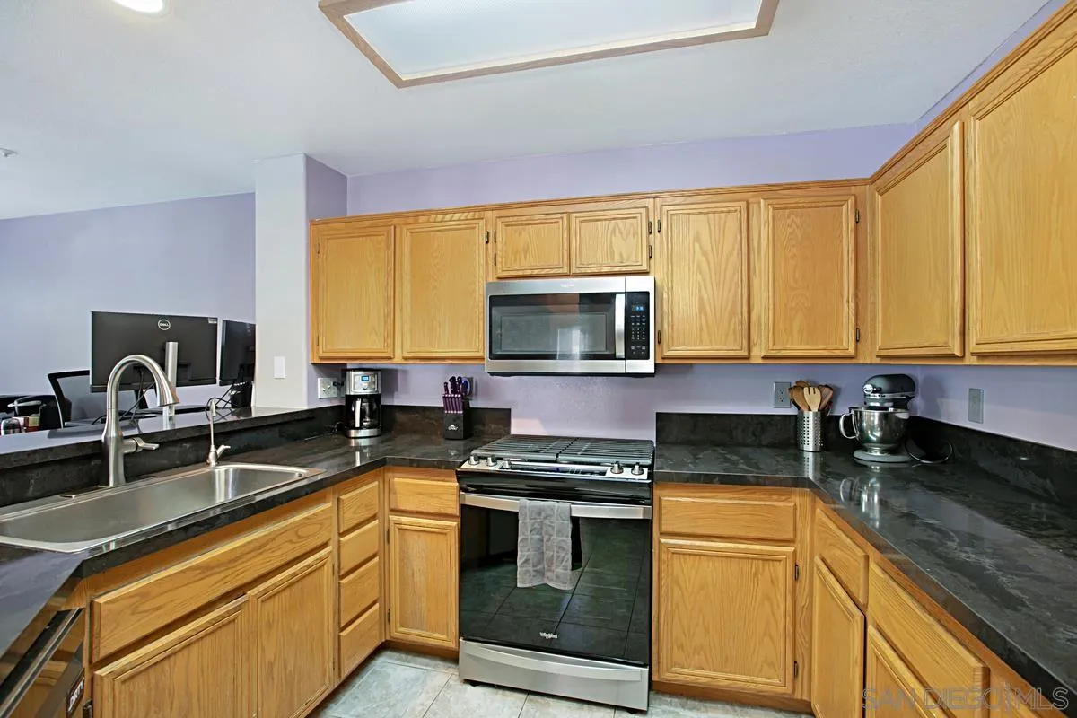405 Whispering Willow Drive, Unit B Santee, CA 92071 - Photo 8 of 29 a kitchen with granite countertop a stove and a sink