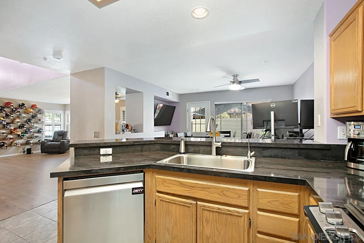 405 Whispering Willow Drive, Unit B Santee, CA 92071 - Photo 9 of 29 a kitchen with stainless steel appliances granite countertop a sink and cabinets