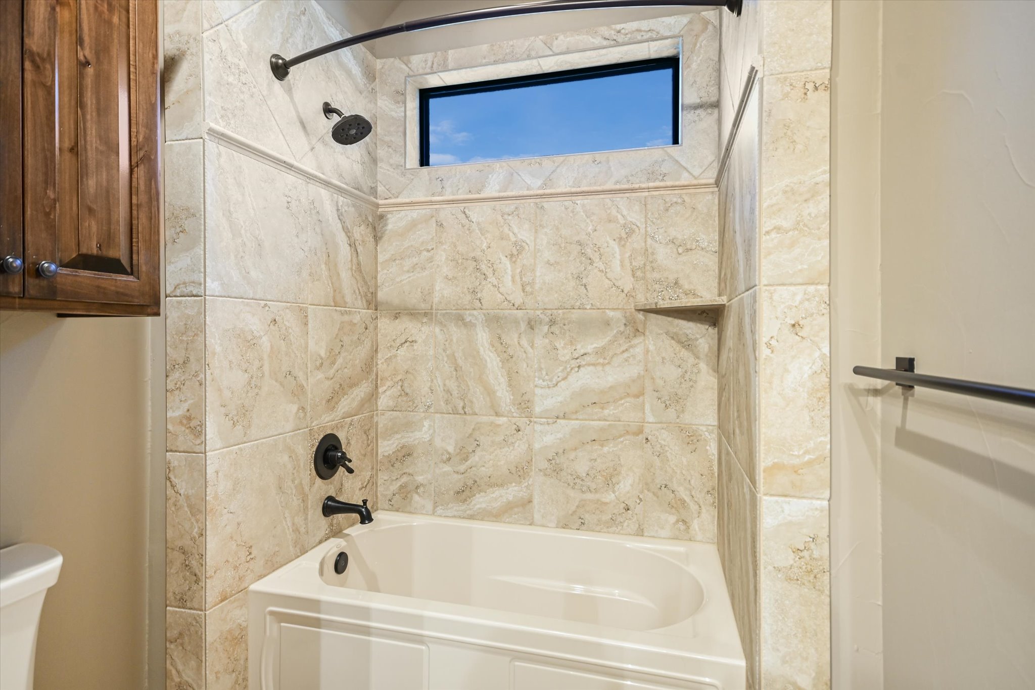 228 Puzzle Pass Spring Branch, TX 78070 - Photo 24 of 35 Marble-look tile surrounds a contemporary bathtub with a transom window overhead.