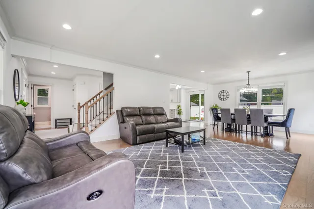 a living room with furniture and a dining table with rug