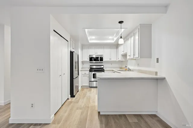 a kitchen with kitchen island a sink stainless steel appliances and cabinets