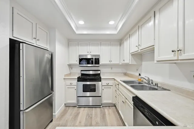 a kitchen with white cabinets and stainless steel appliances