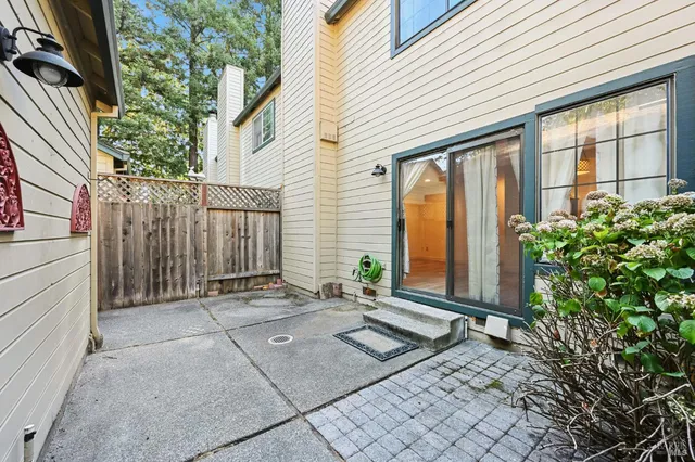 a backyard of a house with potted plants and trees