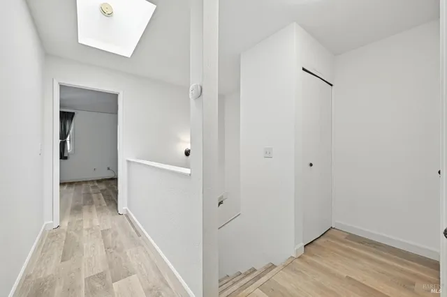 a view of a hallway with wooden floor and closet