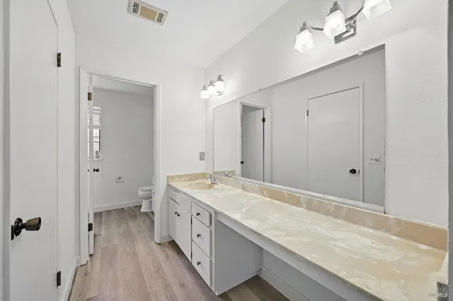 a spacious bathroom with a granite countertop sink a mirror and shower