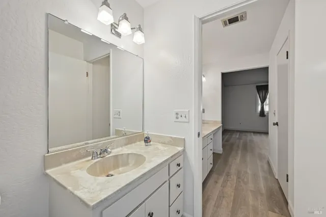a bathroom with a sink vanity granite and a mirror