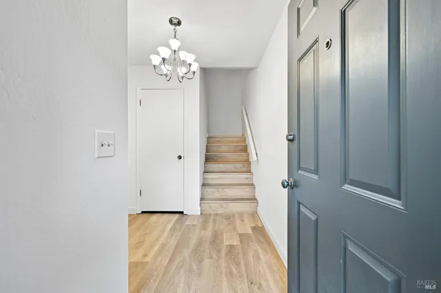 a view of a hallway with wooden floor and staircase