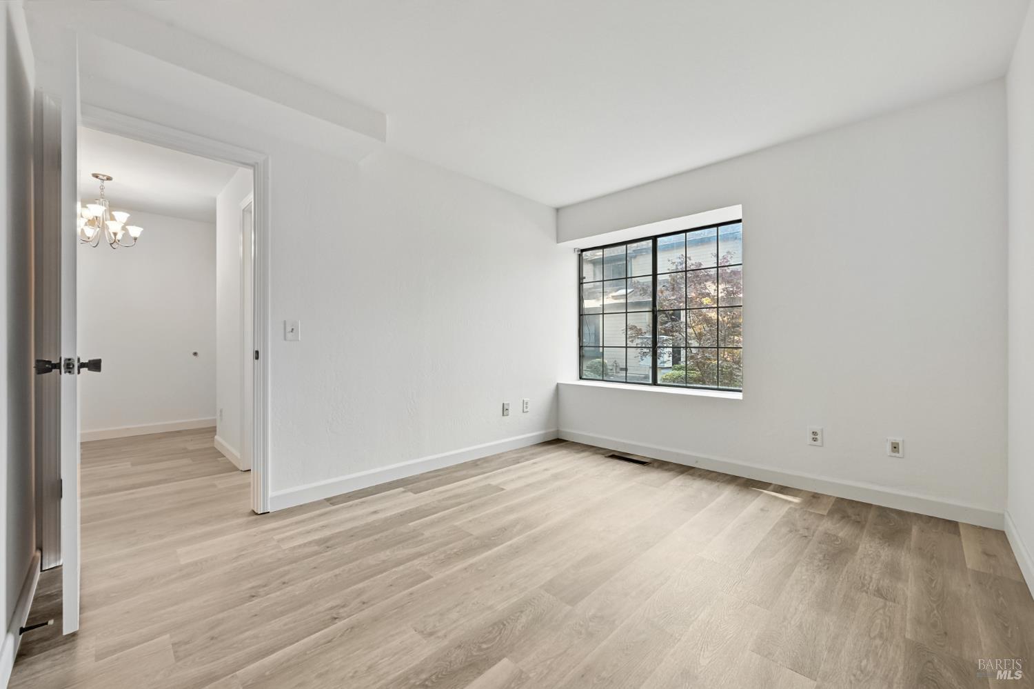 1240 North Street Santa Rosa, CA 95404 - Photo 9 of 36 a view of an empty room with wooden floor and a window