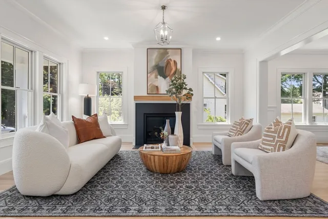 a living room with furniture a fireplace and a large window