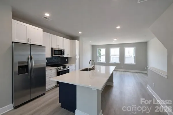 a kitchen with refrigerator cabinets and wooden floor