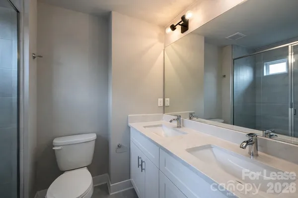 a bathroom with a granite countertop toilet sink and mirror