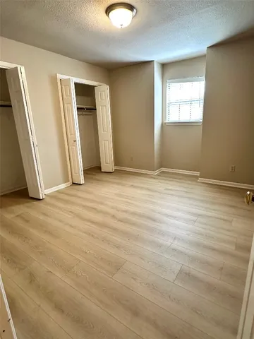 an empty room with closet and windows
